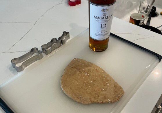 A bottle of whiskey and some food on top of a counter.